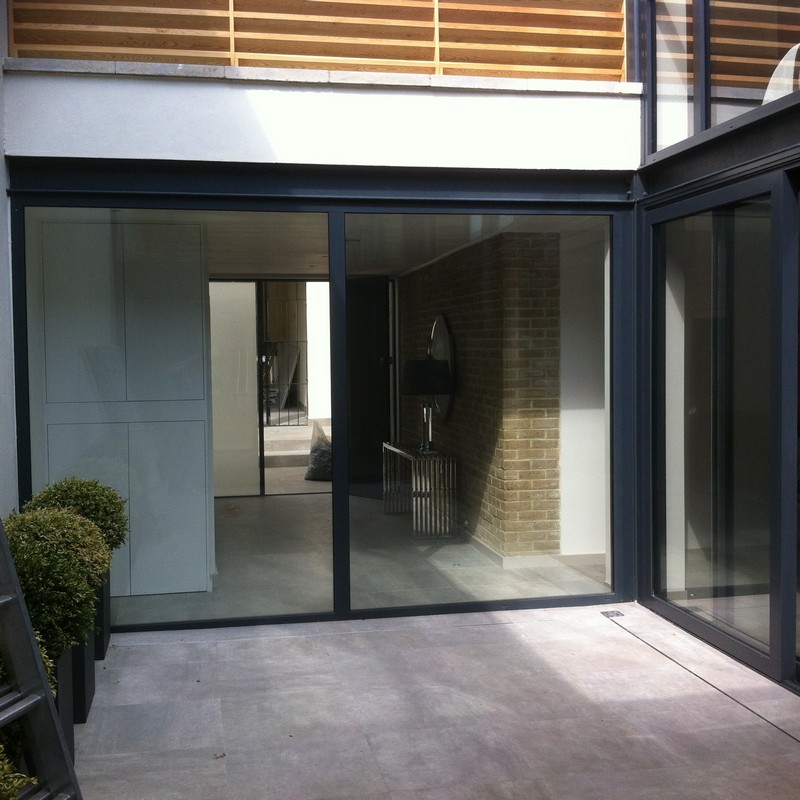 Floor-to-ceiling sliding doors opening to courtyard in Borehamwood