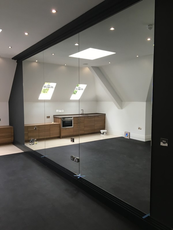 Frameless glass partition in loft conversion by Borehamwood glaziers