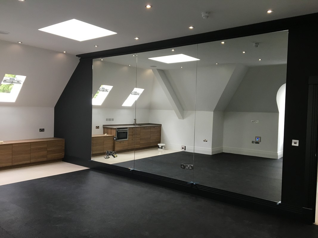 Frameless glass wall dividing loft conversion in Borehamwood